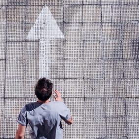 birds eye view of man running over arrow on ground